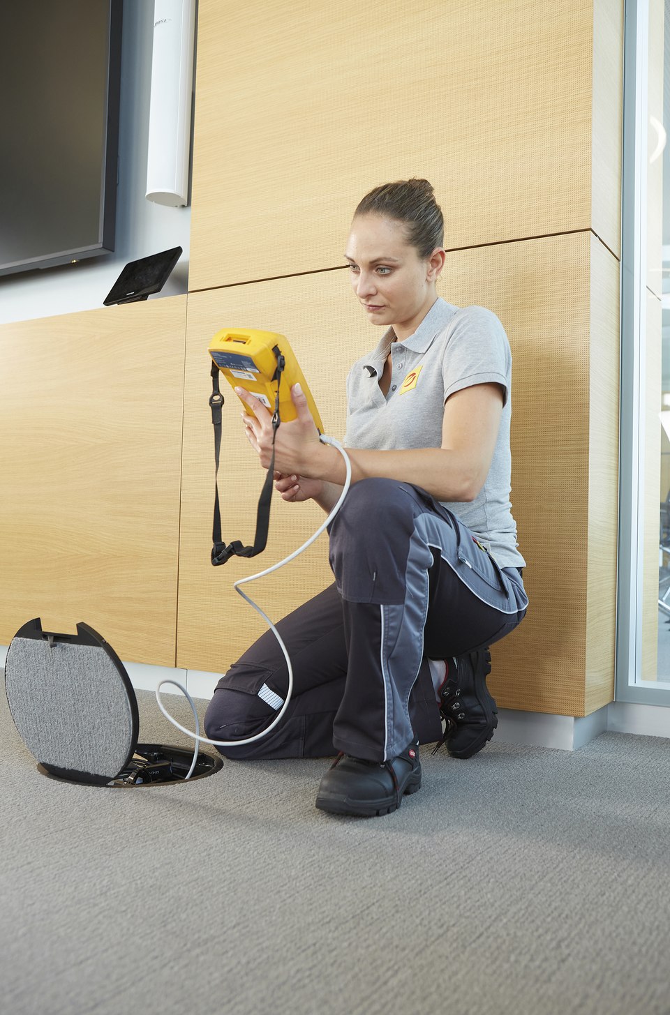 Elektronikerin misst eine Netzwerkverbindung im Büro.